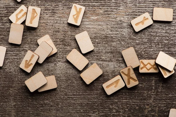 Vue de dessus des runes chamaniques avec des symboles sur la surface en bois — Photo de stock