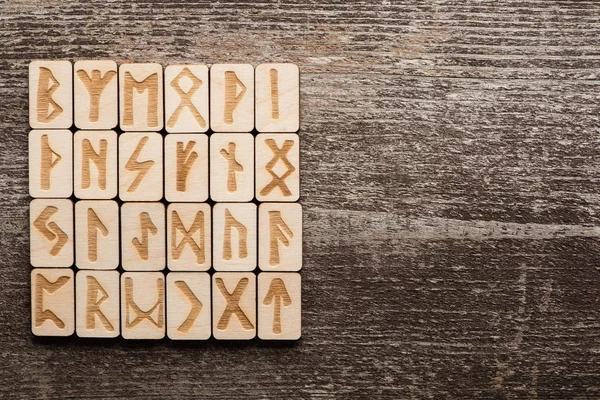 Top view of runes with signs on wooden background with copy space — Stock Photo