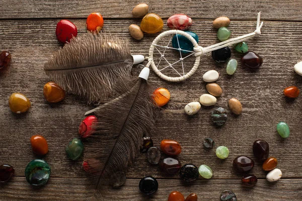 Vue du dessus de dreamcatcher chamanique sur la fortune disant des pierres sur la surface en bois — Photo de stock