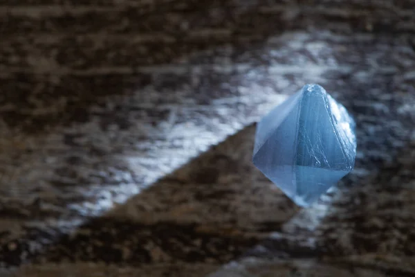 Vista de cerca del cristal mágico azul en la superficie de madera con luz - foto de stock