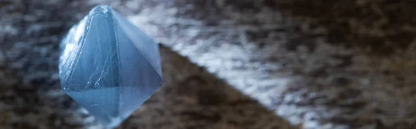 Vue rapprochée du cristal magique bleu sur une surface en bois avec lumière, vue panoramique — Photo de stock