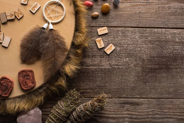 Top view of tambourine, dreamcatcher with smudge sticks and crystals on wooden background — Stock Photo