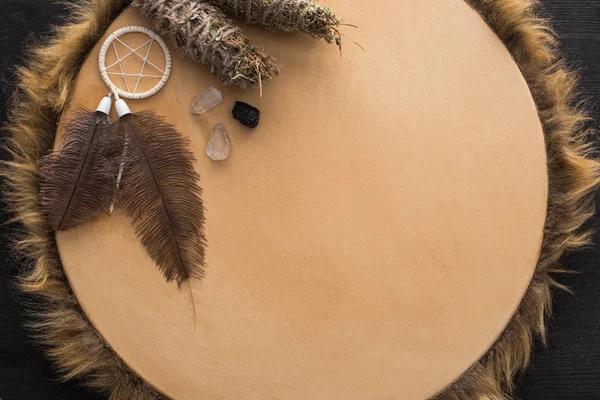 Vue de dessus des bâtons de taches, cristaux et attrape-rêves sur tambourin sur fond de bois foncé — Photo de stock