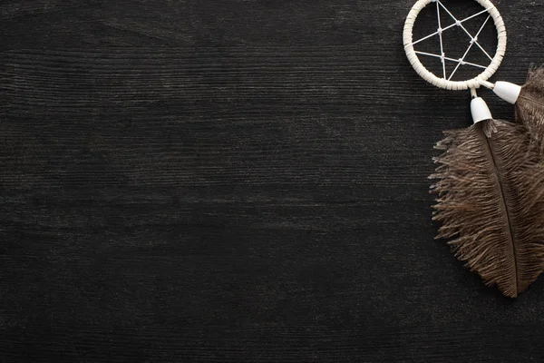 Top view of dreamcatcher with feathers on black wooden background — Stock Photo