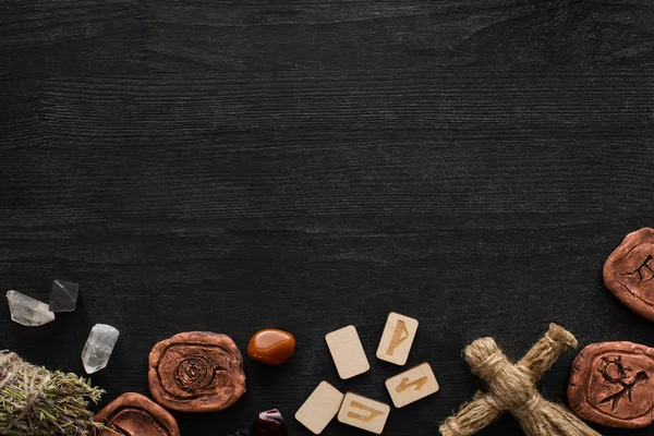 Draufsicht auf schamanische Amulette, Puppe und Runen auf schwarzem Holzgrund — Stockfoto