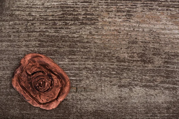 Vista dall'alto dell'amuleto di argilla con simbolo sulla superficie di legno — Foto stock