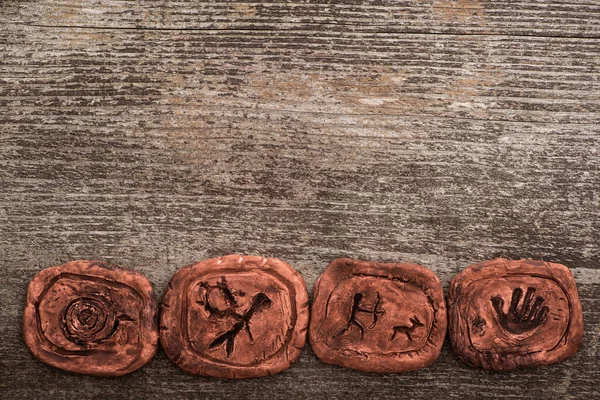 Top view of shamanic clay talismans on wooden background — Stock Photo