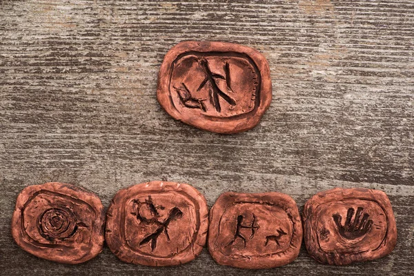 Vue du dessus des amulettes d'argile chamanique sur fond en bois — Photo de stock