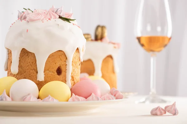 Selektiver Schwerpunkt des Osterkuchens mit bemalten Eiern in der Nähe von Weinglas und Baiser — Stockfoto