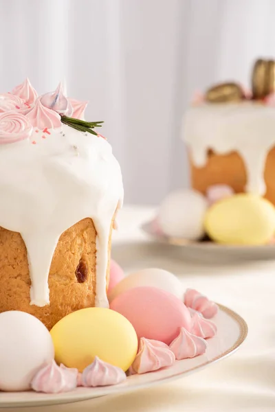 Focus selettivo di deliziose torte pasquali con meringa e uova colorate su piatti — Foto stock
