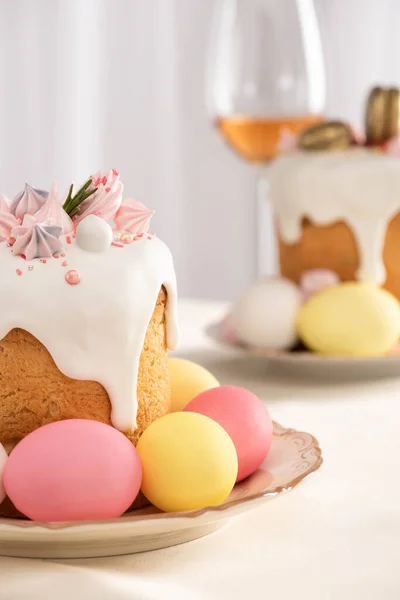 Focus selettivo di deliziose torte pasquali con meringa e uova colorate su piatti — Foto stock