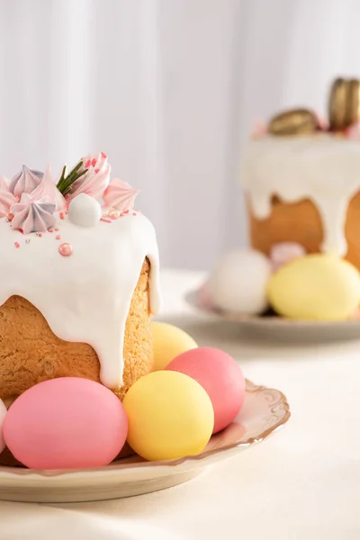 Focus selettivo di deliziose torte pasquali con meringa e uova colorate su piatti — Foto stock