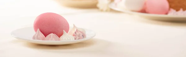 Pink painted Easter egg with meringue on plate, panoramic shot — Stock Photo