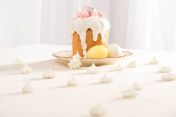 Селективный фокус вкусного пасхального торта возле окрашенных яиц и безе — стоковое фото