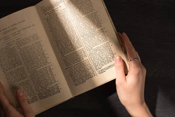 KYIV, UKRAINE - JANUARY 17, 2020: partial view of woman reading holy bible in dark — Stock Photo