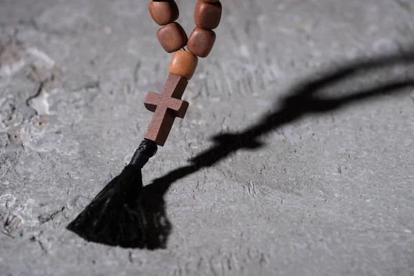 Wooden rosary with cross on grey textured surface — Stock Photo