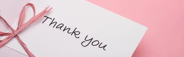 Panoramic shot of pink bow near thank you greeting card on pink background — Stock Photo