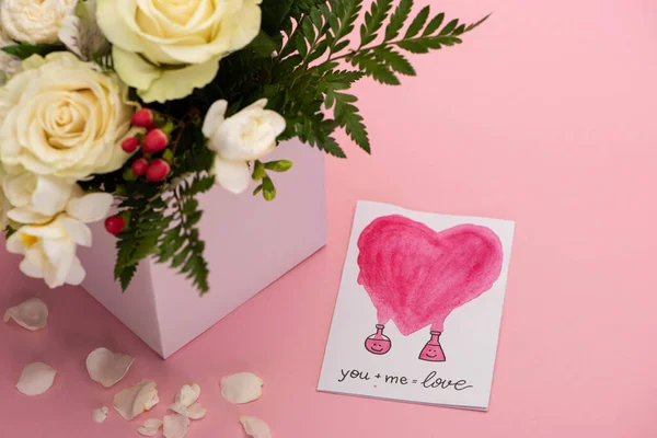 Bouquet di fiori in scatola regalo festivo con biglietto di auguri di San Valentino su sfondo rosa — Foto stock