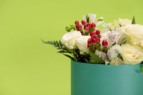 Fresh bouquet of flowers in gift box isolated on green — Stock Photo