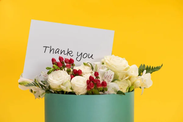 Ramo fresco de flores en caja de regalo con tarjeta de felicitación gracias aislado en amarillo - foto de stock