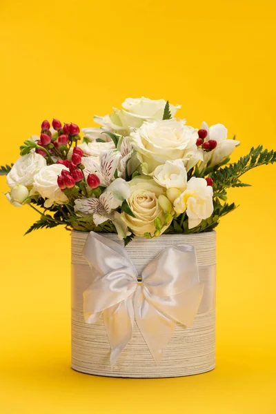 Primavera bouquet fresco di fiori in scatola regalo festivo con fiocco su giallo — Foto stock