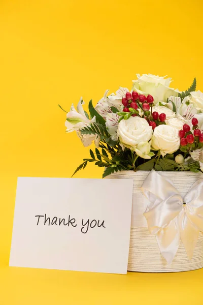 Spring fresh bouquet of flowers in festive gift box with bow near thank you greeting card isolated on yellow — Stock Photo