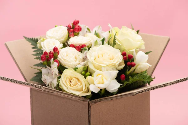 Buquê de flores em caixa de papelão isolado em rosa — Fotografia de Stock