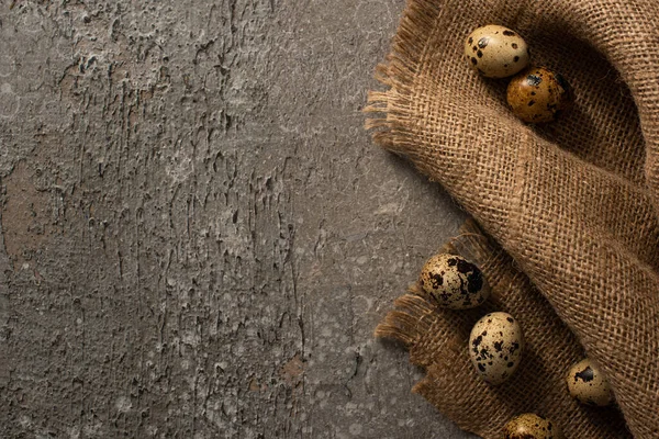 Vue de dessus des oeufs de caille sur sac sur fond texturé gris — Photo de stock