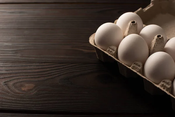 Ovos de galinha branca na bandeja de ovos no fundo de madeira escura — Fotografia de Stock