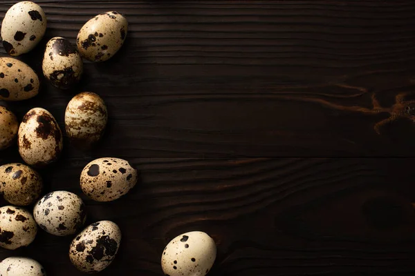Верхний вид перепелиных яиц на коричневой деревянной поверхности — стоковое фото