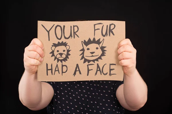 Man with obscure face holding sign with your fur had a face inscription isolated on black — Stock Photo