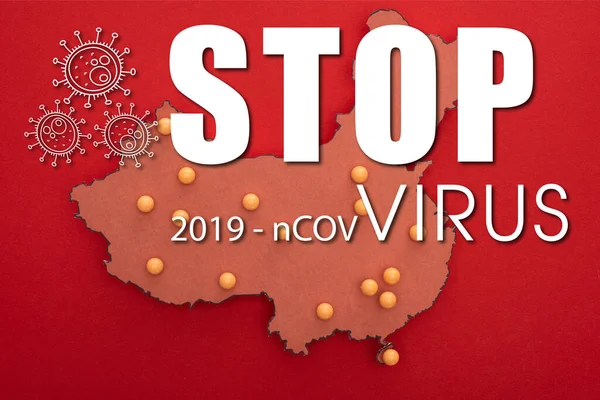 Vue du dessus de la carte de la Chine avec des broches jaunes sur fond rouge avec l'illustration stop virus 2019-ncov — Photo de stock