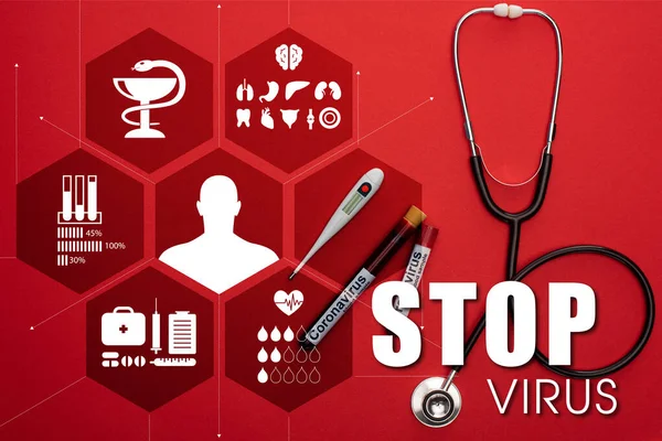 Top view of stethoscope, thermometer and test tubes with blood samples and stop virus lettering on red background — Stock Photo