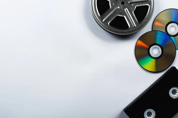 Top view of CD discs, VHS cassette and film reel on white background — Stock Photo