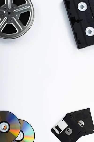 Top view of CD discs, VHS cassette, diskettes and film reel on white background — Stock Photo