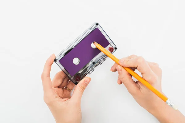 Partial view of man holding purple cassette and pencil on white background — Stock Photo