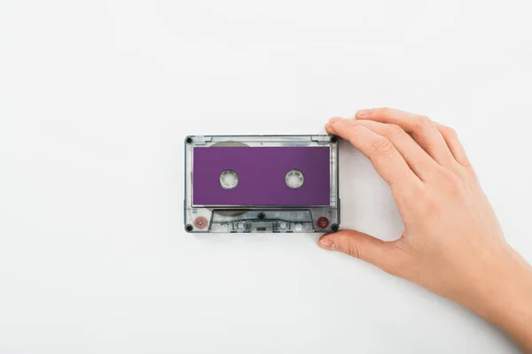 Partial view of man holding purple recording cassette on white background — Stock Photo