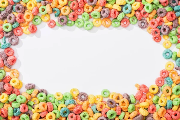 Vista superior de cereales de desayuno multicolores brillantes dispuestos en marco sobre fondo blanco - foto de stock