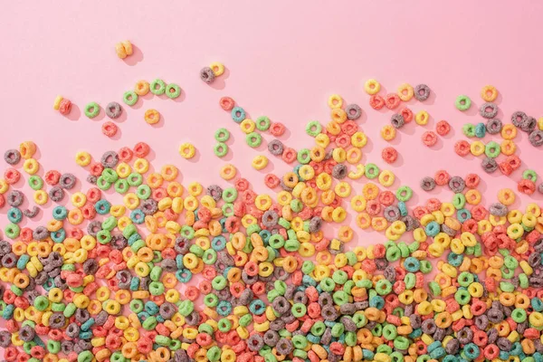 Vue de dessus des céréales de petit déjeuner multicolores lumineuses sur fond rose — Photo de stock