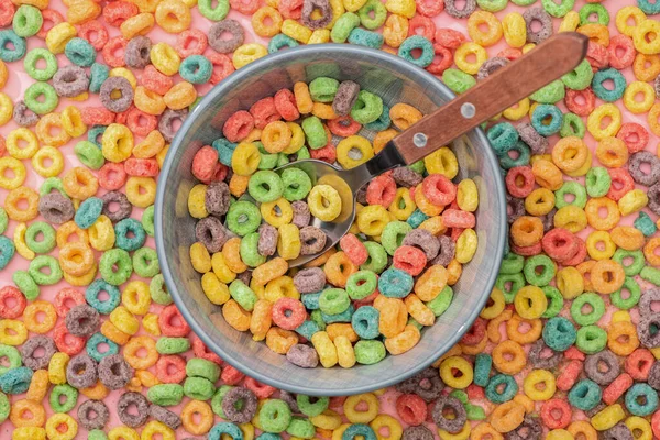 Vista superior de los cereales de desayuno de colores brillantes en un tazón con cuchara - foto de stock