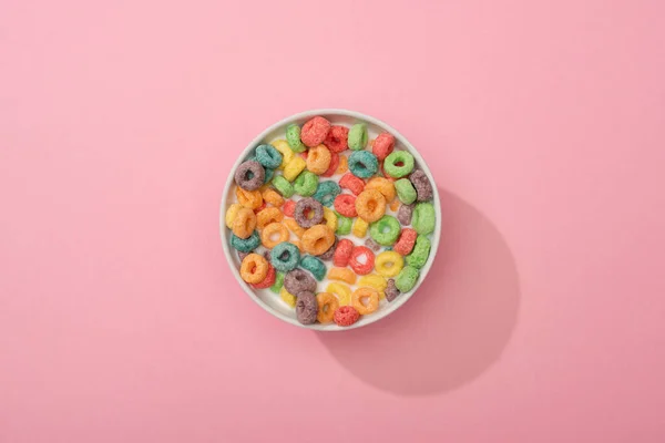 Vue du dessus des céréales colorées vives petit déjeuner dans un bol sur fond rose — Photo de stock