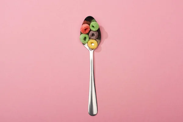 Top view of bright colorful breakfast cereal in spoon on pink background — Stock Photo