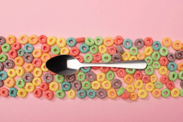 Vista dall'alto di luminoso cereali colorati per la colazione e cucchiaio su sfondo rosa — Foto stock