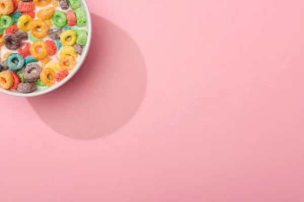 Top view of bright colorful breakfast cereal with milk in bowl on pink background — Stock Photo