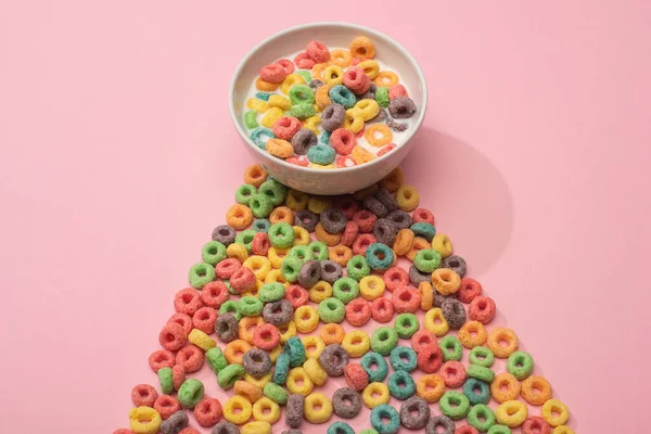 Bright colorful breakfast cereal with milk in bowl and on pink background — Stock Photo