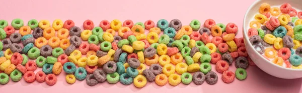 Brillante cereal colorido desayuno con leche en el tazón y sobre fondo rosa, plano panorámico - foto de stock