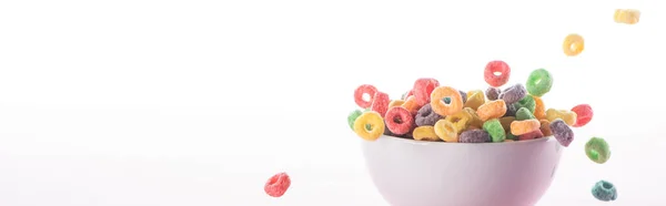 Bright multicolored breakfast cereal falling in bowl isolated on white, panoramic shot — Stock Photo