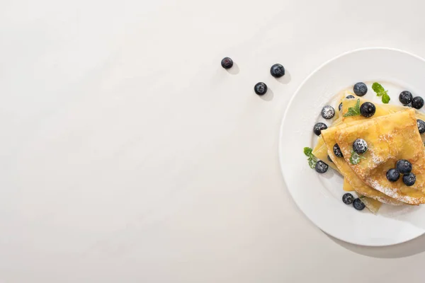 Vue de dessus de crêpes savoureuses aux bleuets et menthe sur fond gris — Photo de stock