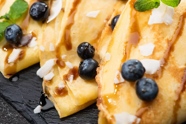 Close up view of tasty crepes with blueberries, mint and coconut flakes — Stock Photo