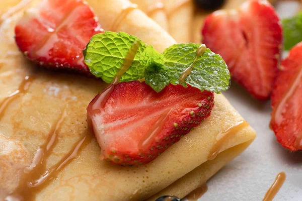 Nahaufnahme von leckeren Crêpes mit Erdbeeren und Minze — Stockfoto